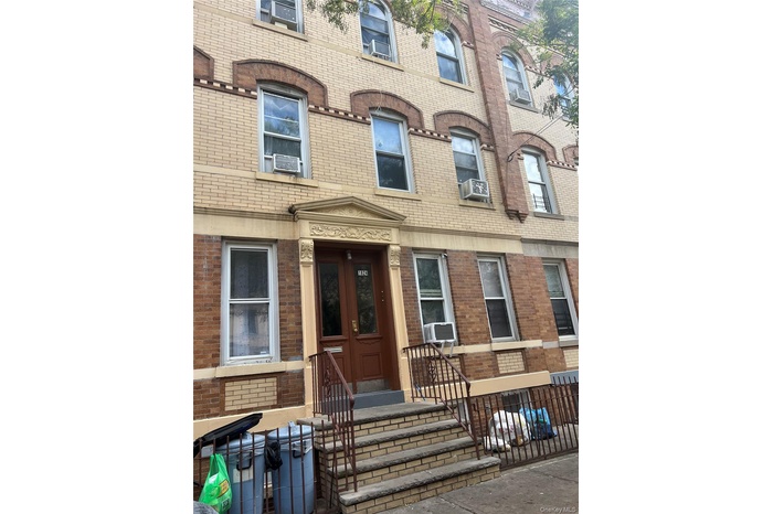 View of exterior entry with brick siding and cooling unit