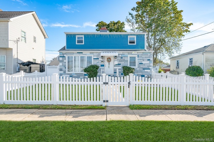 View of front of property with a gate, a fenced front yard, and a chimney