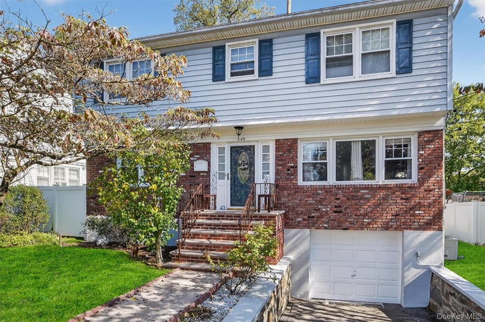 Colonial-style house featuring brick siding and an attached garage