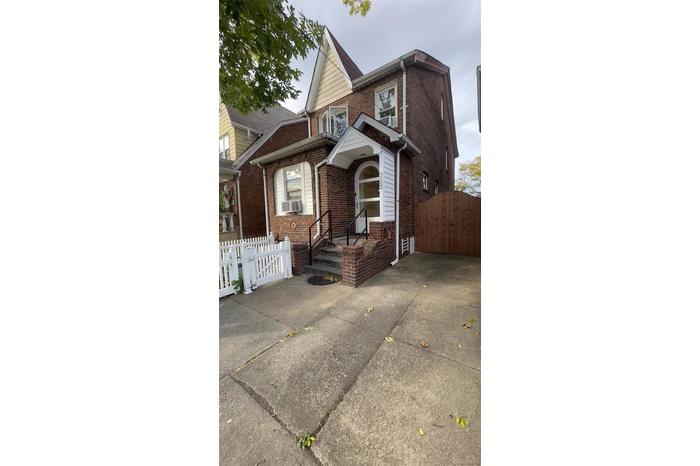 Traditional home featuring brick siding and a gate