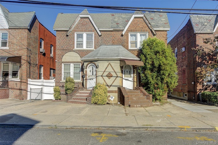 View of front of house with brick siding and a gate