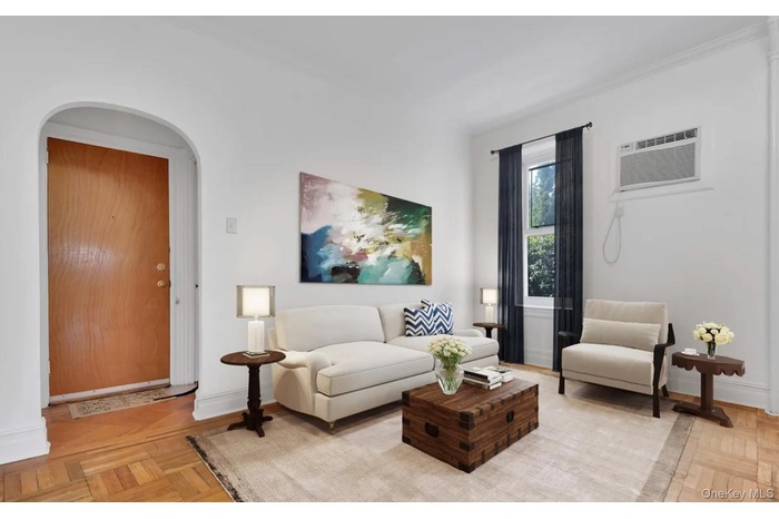 Living room with arched walkways and an AC wall unit