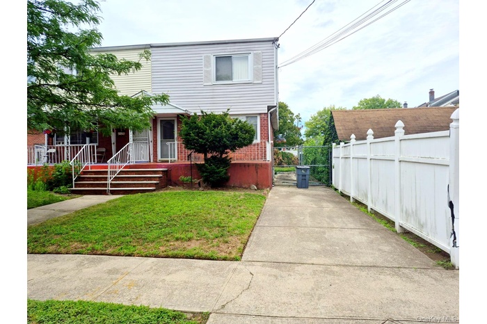 Traditional-style house with brick siding, a gate, and covered porch