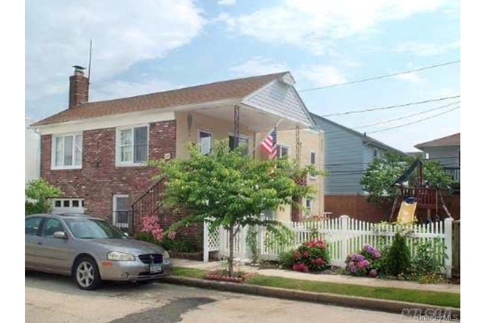 Bungalow-style home with a chimney, brick siding, stairway, and a playground