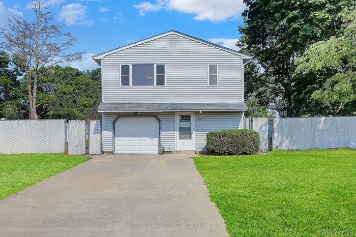 Traditional home with concrete driveway, a garage, and a gate