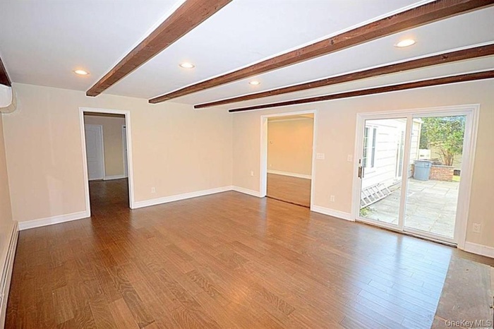 Unfurnished room featuring beam ceiling, recessed lighting, light wood finished floors, and a baseboard radiator