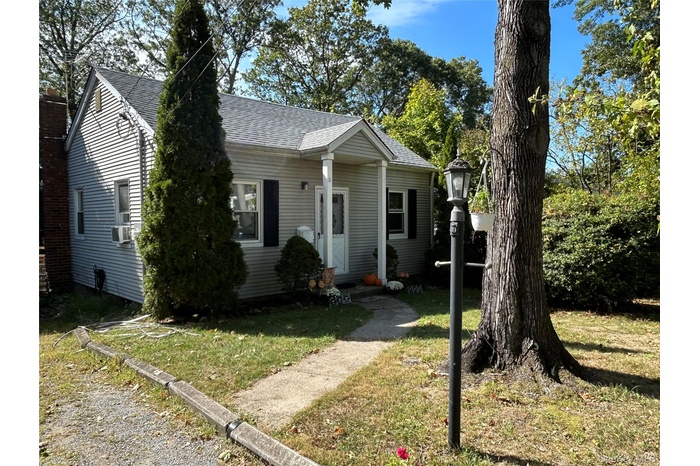 View of front of house featuring roof with shingles and a front yard