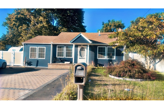View of front facade featuring roof with shingles and a gate