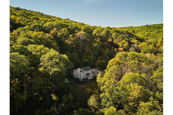 View of subject property with a forest