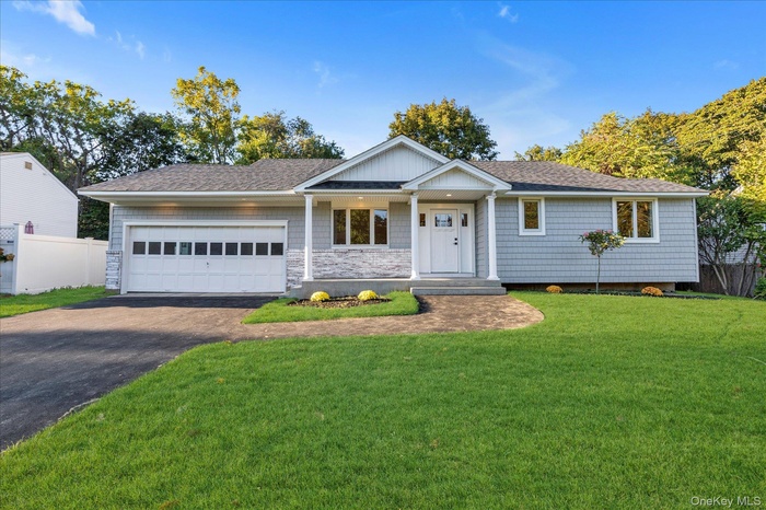 Single story home with driveway, covered porch, roof with shingles, a garage, and stone siding