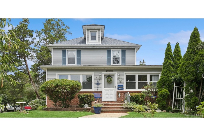 American foursquare style home with brick siding and a front yard