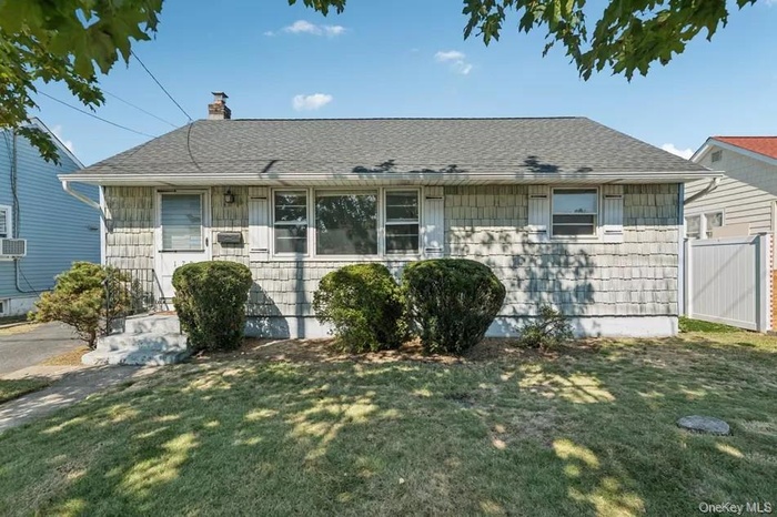 View of front of property with roof with shingles and a chimney