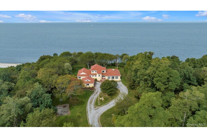 Aerial view of property and surrounding area with a nearby body of water
