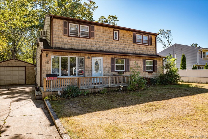 View of front of home with an outbuilding, a garage, and concrete driveway