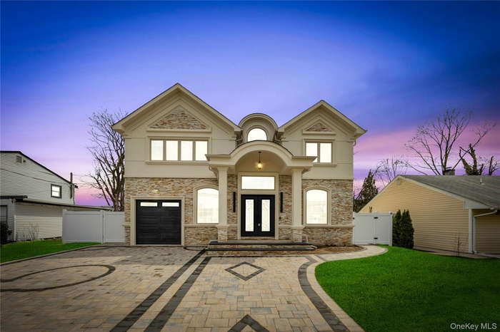 View of front of property featuring a gate, decorative driveway, stone siding, and french doors