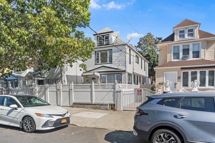View of front of home featuring a fenced front yard, a gate, and a shingled roof