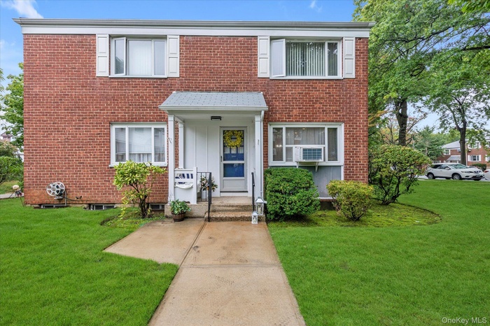 View of front of home featuring a front lawn and brick siding