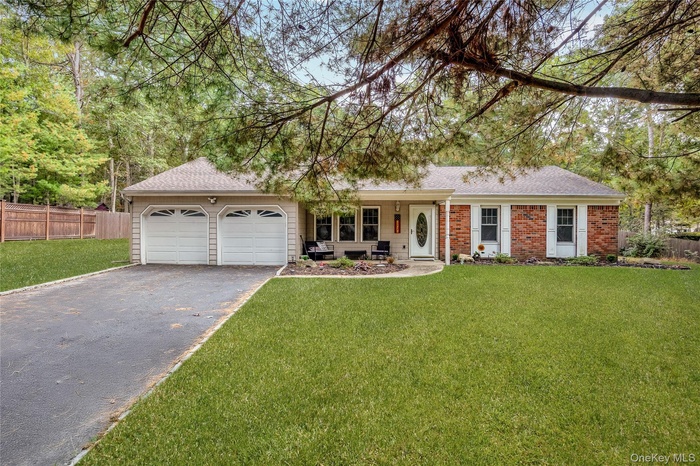 Ranch-style house featuring roof with shingles, asphalt driveway, and a garage