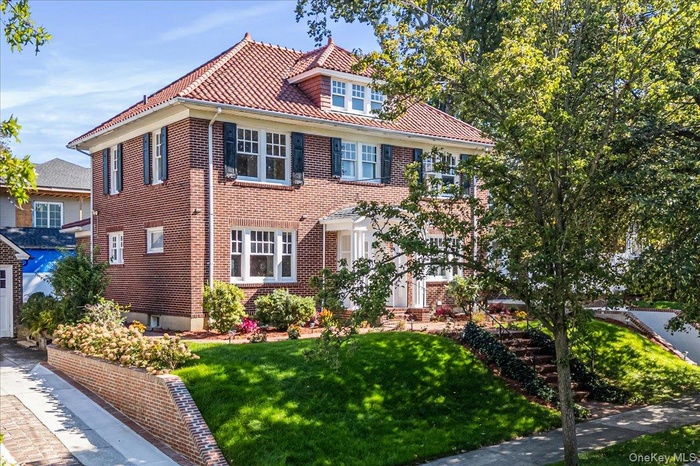 View of front of house with a front yard and brick siding