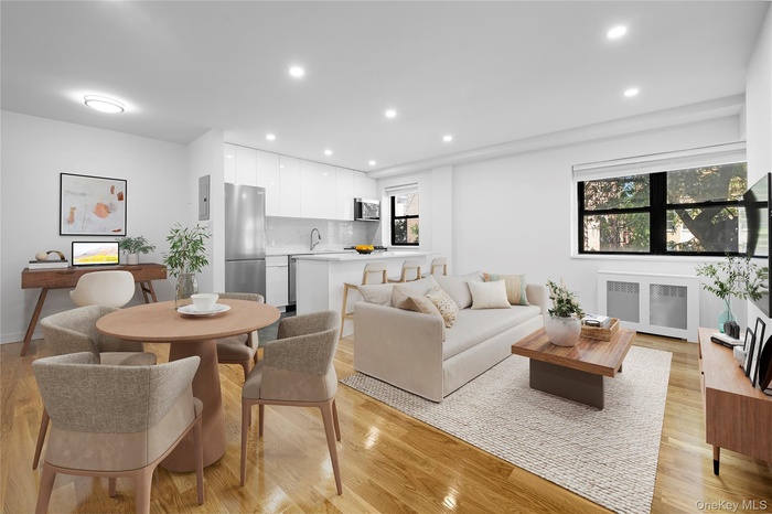 Living area featuring radiator heating unit, recessed lighting, and light wood-type flooring
