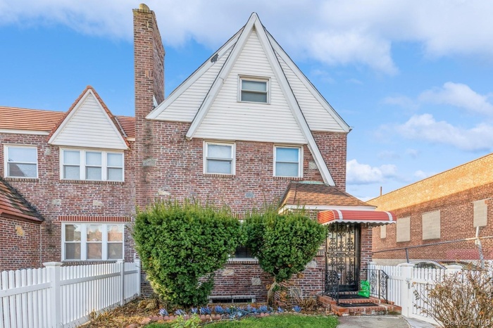 View of front of home featuring brick siding and a chimney