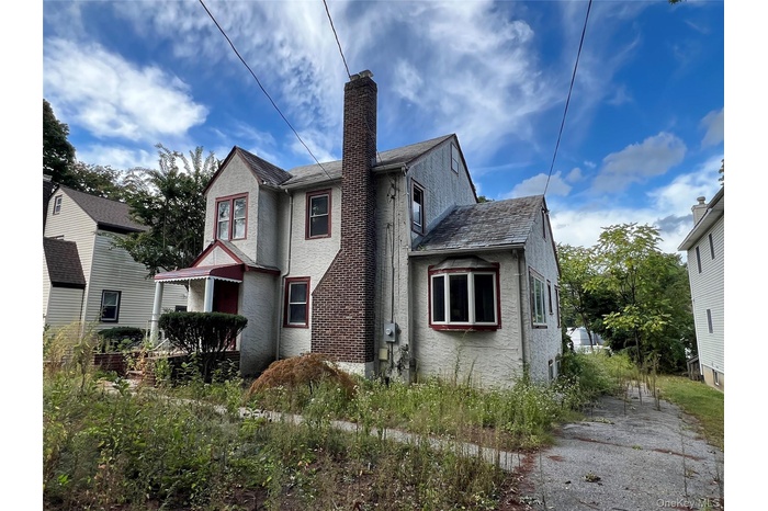 View of side of home with a chimney and stucco siding