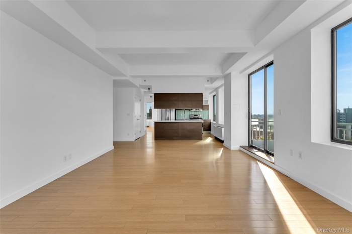 Hall featuring radiator heating unit, light wood-type flooring, and beamed ceiling