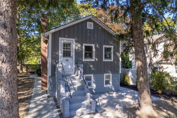 View of front of property featuring board and batten siding and a chimney