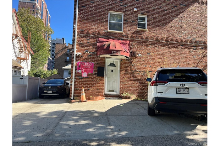View of front of home with brick siding, a garage and private driveway