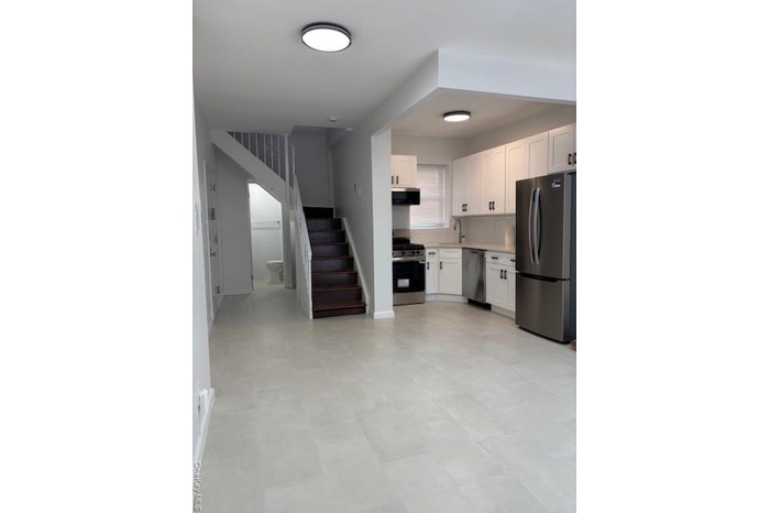 Kitchen with refrigerator, light countertops, white cabinetry, white stove, and dishwashing machine