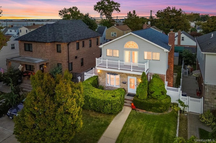 Traditional-style house with a residential view, a balcony, and a chimney