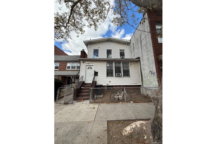 Rear view of house featuring a fenced front yard and a gate