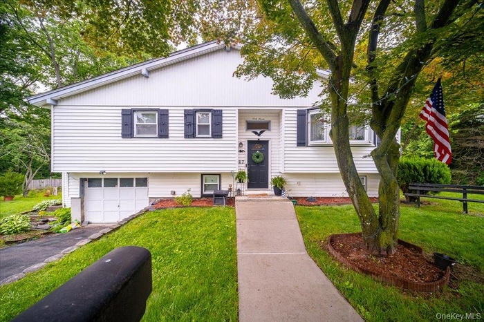 Split foyer home featuring a garage and asphalt driveway