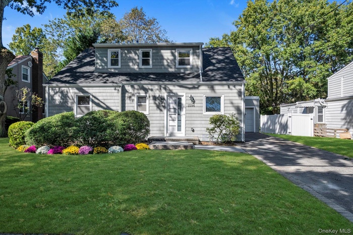 View of front of home with driveway and roof with shingles