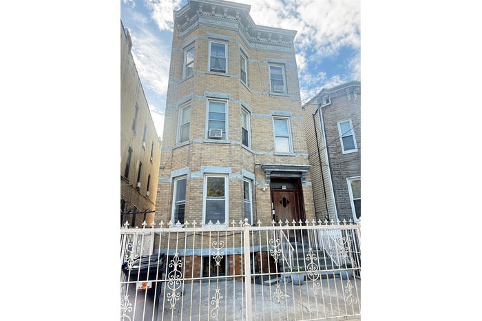 Italianate house featuring brick siding and a fenced front yard