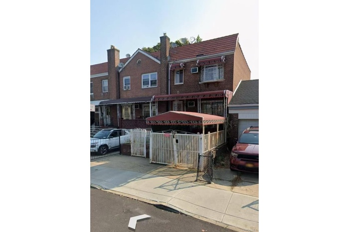 View of front of house with a fenced front yard and brick siding