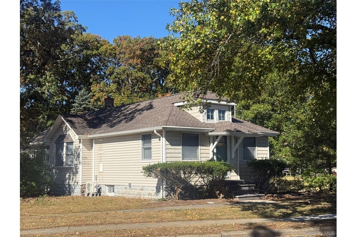 Bungalow-style home with roof with shingles and a chimney