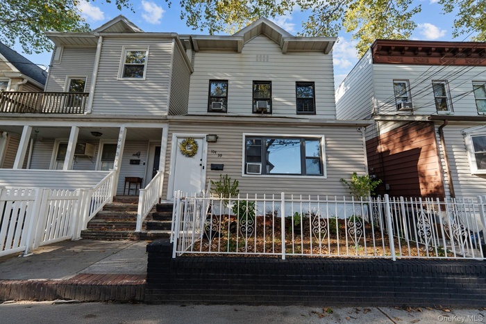 View of front of home featuring a fenced front yard, covered porch, and cooling unit