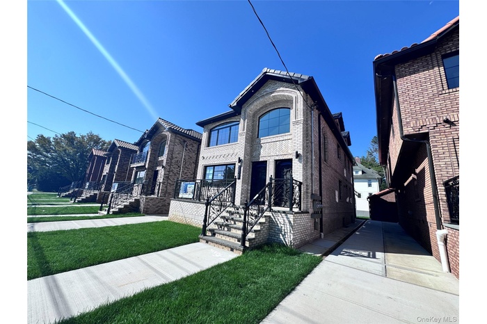 View of front of house featuring a front lawn and brick siding