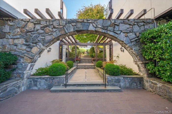Gate with a pergola and a patio area