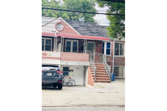 View of front of house featuring a shingled roof and brick siding