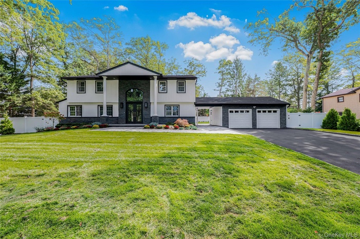 View of front of house with french doors, driveway, stucco siding, stone siding, and an attached garage