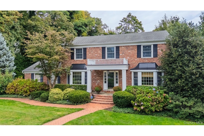 Traditional elegant Brick Georgian Center Hall Colonial Brick walkway leads to bluestone portico entrance