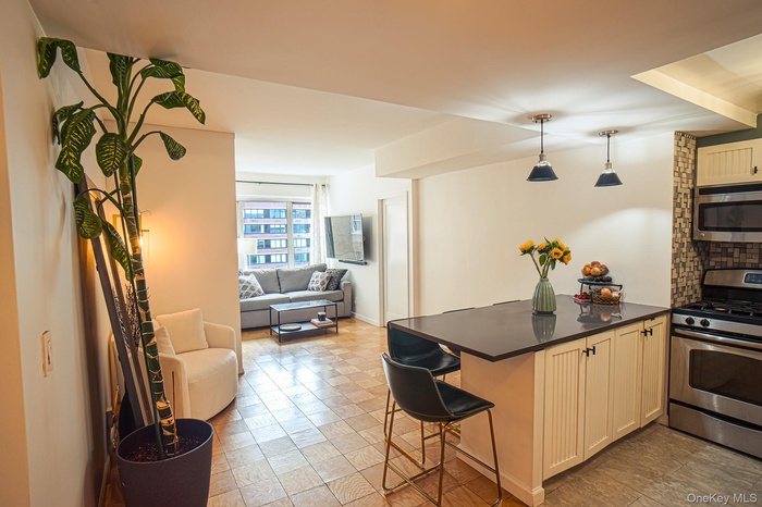 Kitchen featuring appliances with stainless steel finishes, pendant lighting, a kitchen bar, open floor plan, and a peninsula