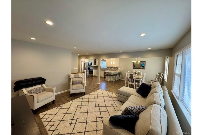 Living area featuring dark wood-style floors and recessed lighting