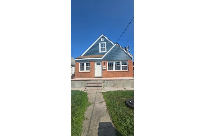Bungalow featuring brick siding