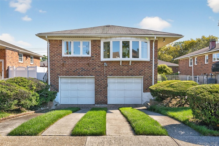 View of front of home with a Two Car attached garage, brick siding, and driveway