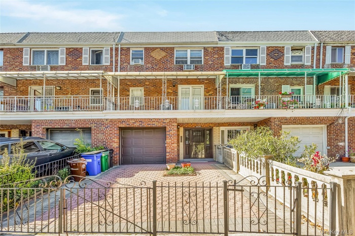 View of front of house featuring a gate, driveway, a fenced front yard, and brick siding