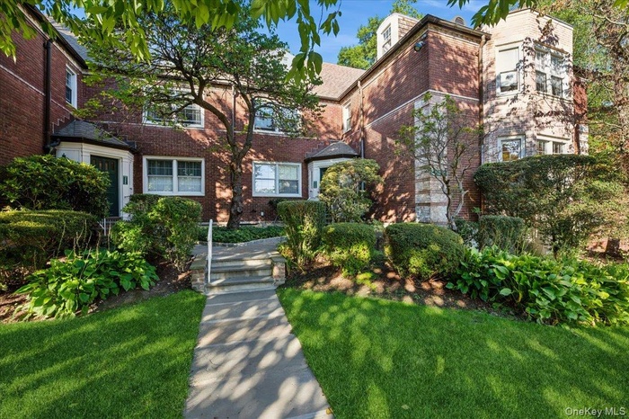 View of front of house with brick siding and a front yard