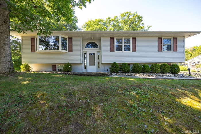 Front of home with landscaping and trees